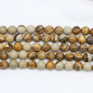 Macro detail of round natural stone beads with landscape patterns in an orderly array