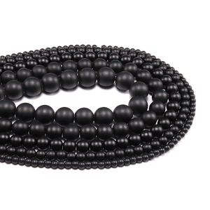 Macro detail of various sizes of matte black natural stone beads for DIY jewelry making