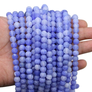 Blue weathered agate loose beads with frosted cracked texture held by hand for jewelry DIY
