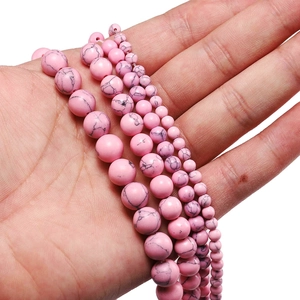 Detailed view of pink turquoise beads in multiple sizes with natural grey marble veining