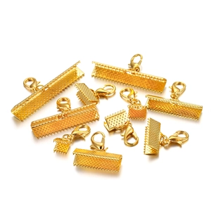 Macro-opname van vergulde karabijnsluitingen en lintklemmen voor het maken van DIY-sieraden