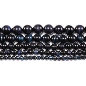 Macro shot of dark blue tiger eye beads in five sizes showing chatoyancy effect