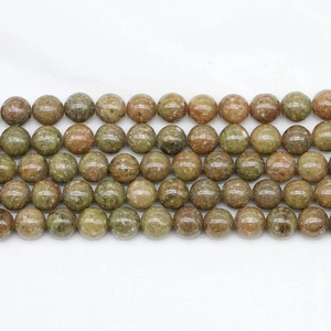 Macro view of round natural green aventurine beads with smooth polished texture