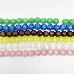 Macro view of polished round cat eye beads in various pastel colors for DIY jewelry