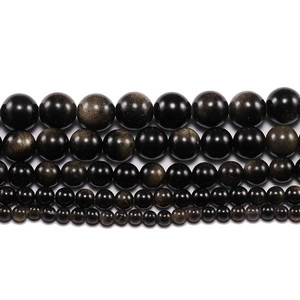 Macro detail of natural obsidian beads in five sizes with metallic luster on white background