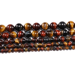 Detail of tiger eye stone beads showing various sizes and glossy chatoyancy effect