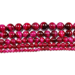 Macro detail of rose red tiger eye stone beads showing silk luster and chatoyancy