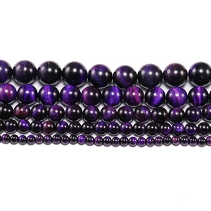 Macro view of purple tiger eye beads in five sizes with silky cat eye luster effect