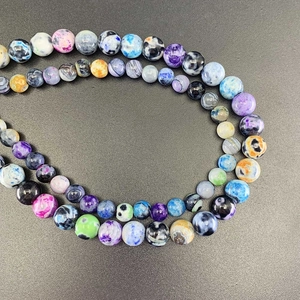 Macro detail of polished multi-colored variegated agate round beads with unique textures
