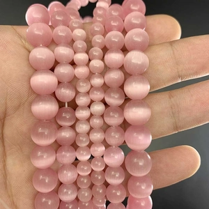 Detailed view of pink cat eye round beads in various sizes for DIY jewelry making
