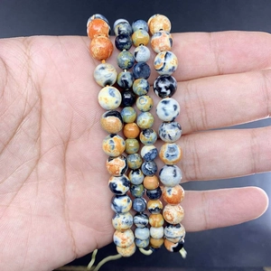 Detailed view of colorful natural fire agate round beads with marble texture in hand