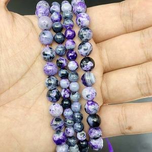 Macro view of polished purple flame agate round beads with natural marble textures