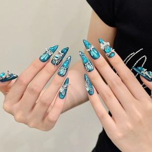 Handmade stiletto press-on nails in blue cat eye with 3D crystal bow and evil eye accents
