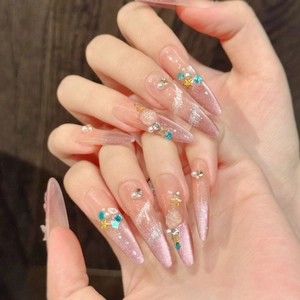 Pink cat-eye press-on nails with 3D sea shells, pearls and star charms in stiletto shape