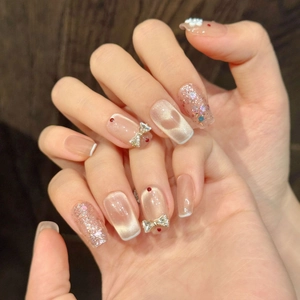 Sparkling cat-eye press-on nails with white 3D flowers and bow-knot rhinestones