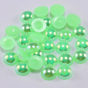 Macro shot of light green AB flatback half pearls with iridescent finish for DIY crafts