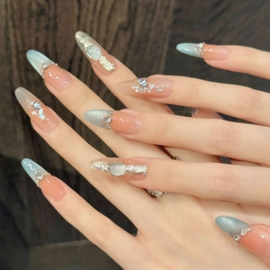 Handmade almond press-on nails with blue cat-eye effect and rhinestone accents