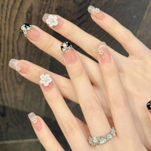 French bow press-on nails with 3D white flowers, pearls and black dot french tips