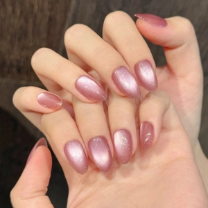 Sparkling rose pink cat eye press-on nails in elegant long almond shape on hands