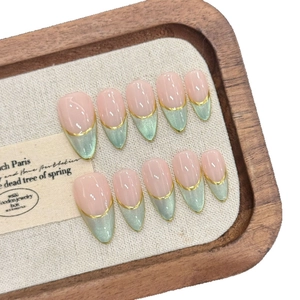Handmade almond nails with green cat eye French tips and gold line accents