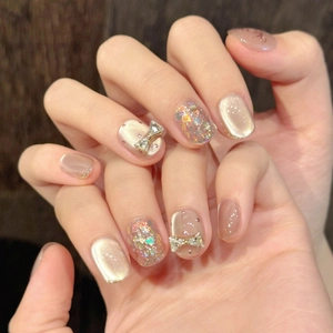Cat eye press-on nails with bow rhinestones and champagne glitter finish