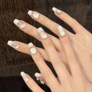 Pink cat eye press-on nails with white French tips and 3D bow accent on long coffin shape