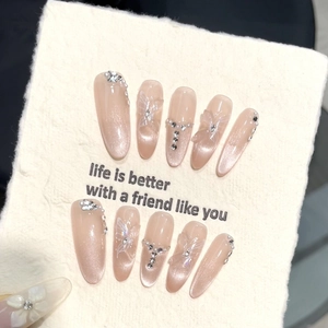 Nude cat eye press-on nails with 3D butterfly, rhinestones and pearls on display card