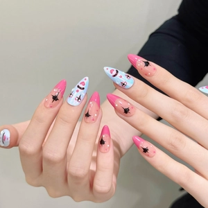 Almond shaped press-on nails with pink French tips and black starburst graffiti designs