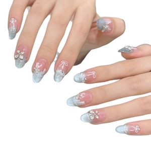 Blue cat eye press-on nails with silver glitter, hand-painted bows, and tiny rhinestones
