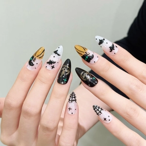 Halloween press-on nails featuring pumpkin, bat and spider web designs on long almond nails