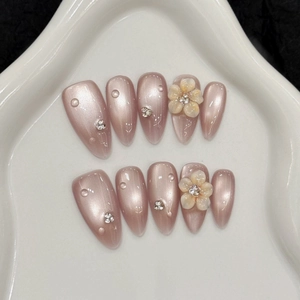 Pink cat-eye press-on nails set with 3D embossed flowers and sparkling rhinestones