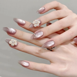 Handmade almond press-on nails with purple cat-eye gel, relief flowers and pearls