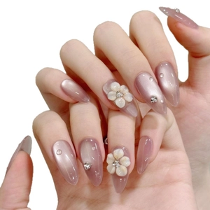 Almond-shaped purple cat-eye press-on nails with 3D white flowers and rhinestones