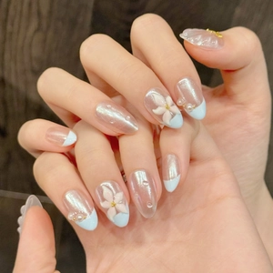 Blue almond press-on nails with 3D floral carvings, pearl accents, and aurora cat-eye finish