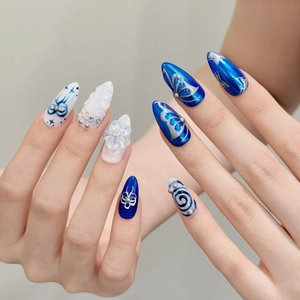 Blue and white almond press-on nails with 3D embossed flowers, silver butterflies and pearls