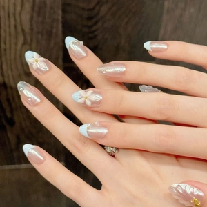 Short almond press-on nails with blue and pink aurora pearl finish and 3D floral accents