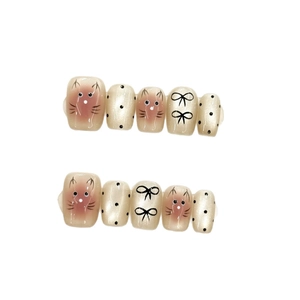 Faux ongles courts carrés avec visages de chats et nœuds noirs sur une base blanc perle