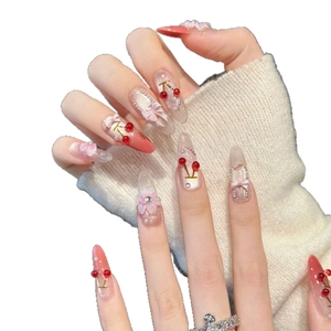Handgemaakte plaknagels met 3D-kersen, roze strikjes en parels op amandelvormige tips