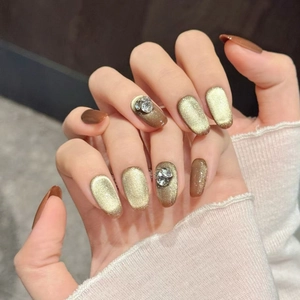 Champagne cat-eye press-on nails with golden amber finish and 3D rhinestones