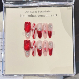 Handmade press-on nails set with festive red cat-eye finish and 3D bow in a display box