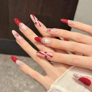 Christmas themed press-on nails with 3D bows and snowflake designs in festive red