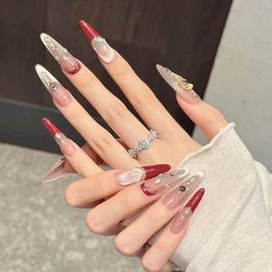 Burgundy cat-eye stiletto press-on nails with crystal accents and French tip design