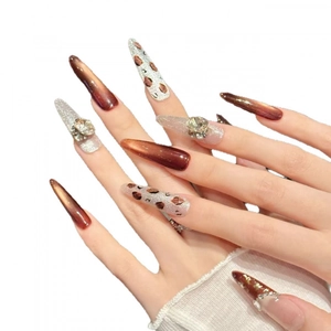 Ongles stiletto avec fini œil de chat, motif léopard et ornements en strass cristal