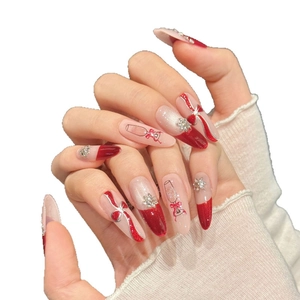 Christmas almond press-on nails with red bows, snowflake rhinestones and glitter