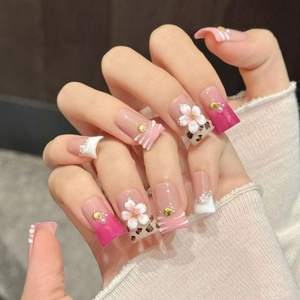 Pink gradient press-on nails with 3D white flowers, pearls, and leopard print designs