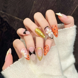 Handmade press-on nails with 3D floral art, gold foil, and chic orange polka dot patterns