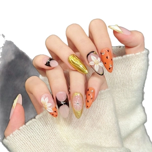 Handmade almond press-on nails with 3D floral relief and gold foil accents on a hand