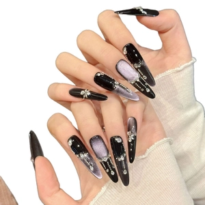 Long stiletto press-on nails with purple cat-eye effect, silver rhinestones and tassels