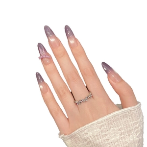 Lilac gradient cat-eye press-on nails with 3D bow accent on model's hand