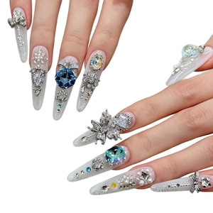 Faux ongles faits main de luxe avec cristaux bleus, perles et nœuds papillon argentés